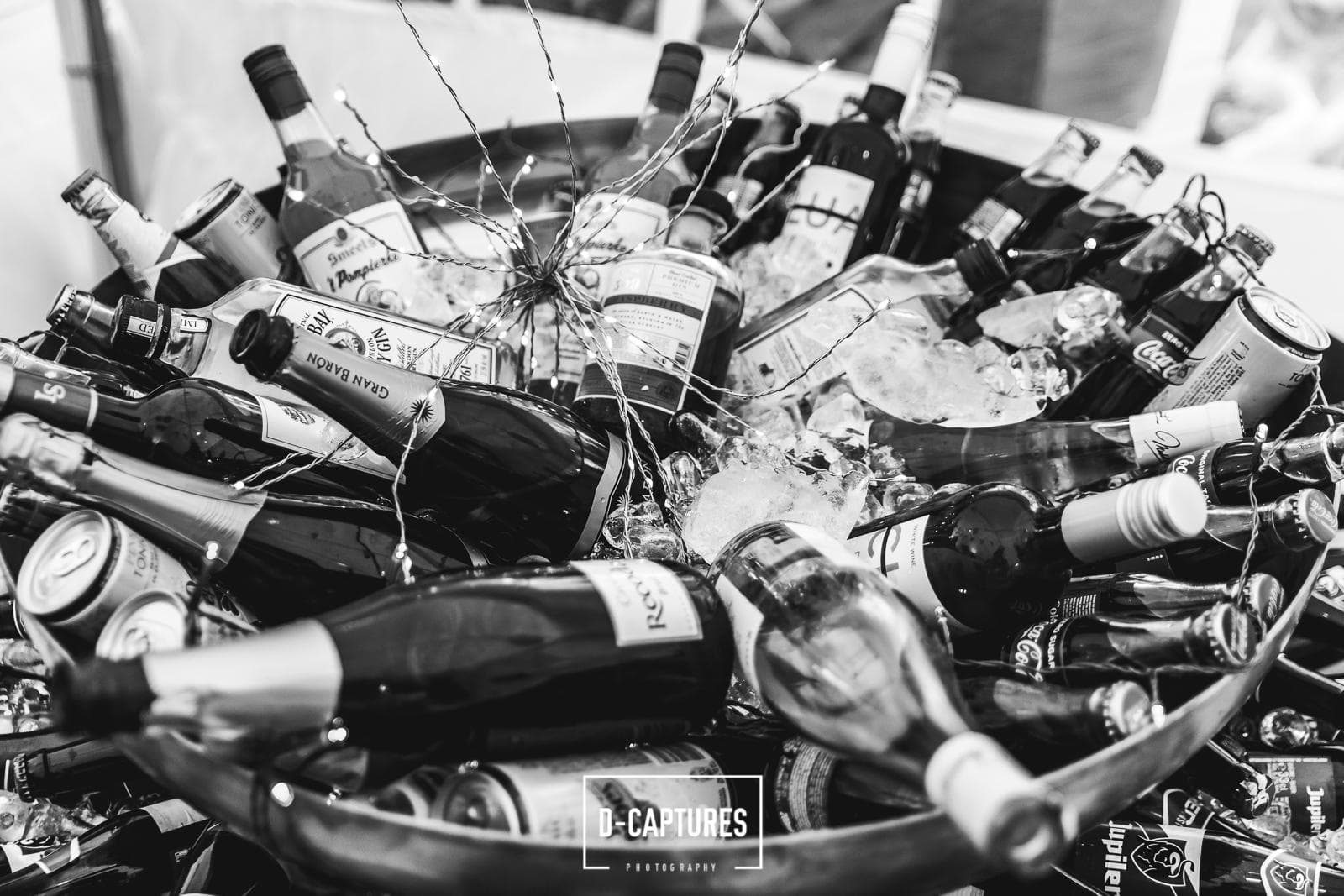 Ijsemmer met drankjes en fairy lights op een bruiloftsreceptie — feestelijke details door The ID, zwart-wit.