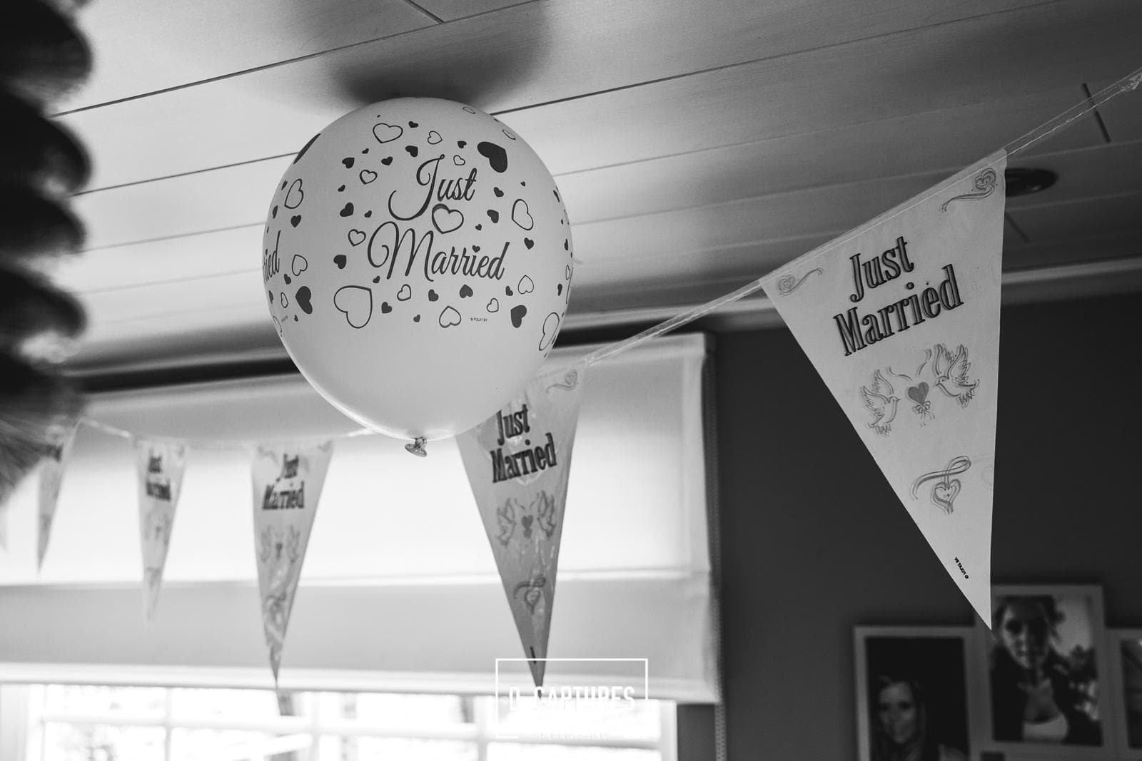 Just Married-ballon en vlaggenslinger als bruiloftsdecoratie — speelse details bij een The ID-receptie, zwart-wit.